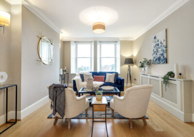 Professionally staged home by Beau Property Home Staging. Show home lounge area featuring coffee table, designer seating with decorative throws and cushions