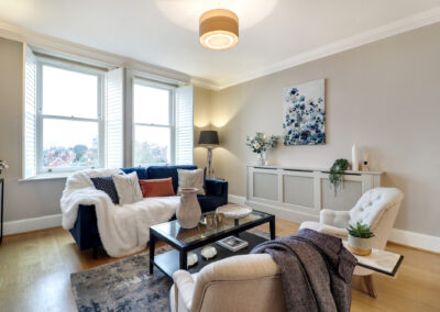 Professionally staged home by Beau Property Home Staging. Show home lounge area featuring coffee table, designer seating with decorative throws and cushions