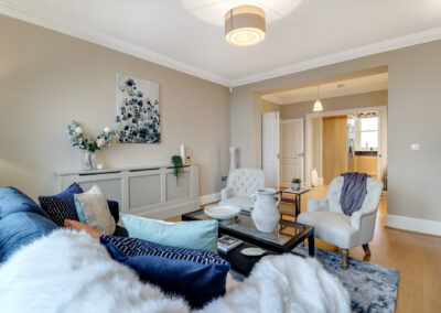 Professionally staged home by Beau Property Home Staging. Show home lounge area featuring coffee table, designer seating with decorative throws and cushions