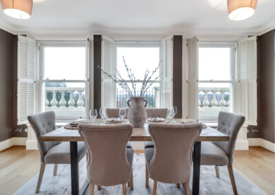 Professionally staged home by Beau Property Home Staging. Show home dining area featuring set table with vase & plants