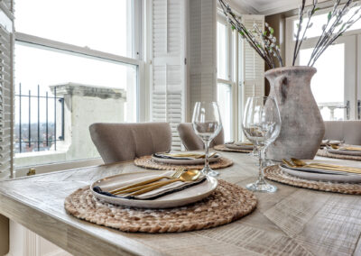 Professionally staged home by Beau Property Home Staging. Show home dining area featuring close up of set table