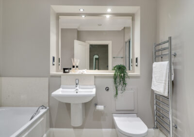 Professionally staged home by Beau Property Home Staging. Show bathroom, featuring large mirror, ornaments and plant