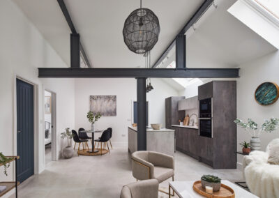 Professionally staged home by Beau Property Home Staging. Show home kitchen / dining area, featuring set table, several plants, hanging artwork & kitchenware