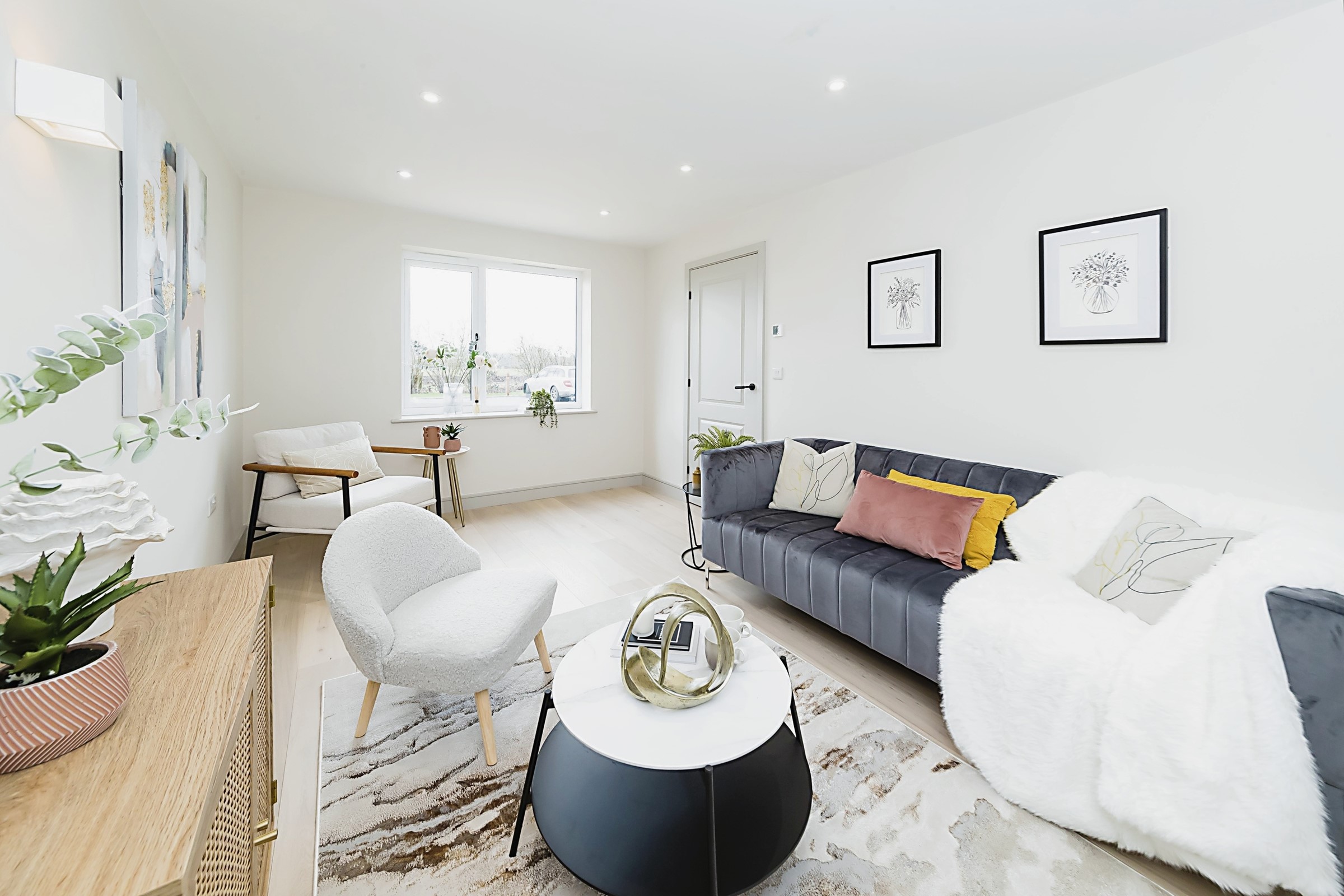 Professionally staged home by Beau Property Home Staging. Show home lounge featuring staged sofa with cushions & throw. decorative ornament on the coffee table.