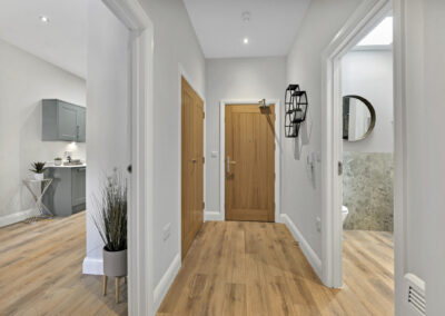 Professionally staged home by Beau Property Home Staging. Show home hallway featuring custom shelving, plants and mirror
