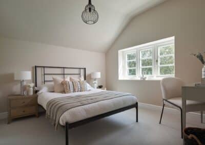 Cozy and harmonious bedroom with metal frame bed and window seat in a staged home in Tunbridge Wells, highlighting the finesse of home staging.