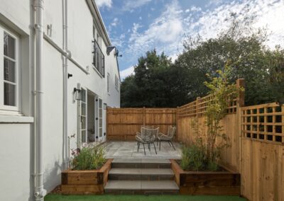Charming and tranquil backyard with patio area and rattan chairs in a staged home in Tunbridge Wells, exemplifying the art of home staging.