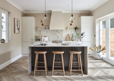 Staged home kitchen in Tunbridge Wells with kitchen island in focus. Decorative ornaments, minimalist style. Light and airy feel with gold and dark accents.