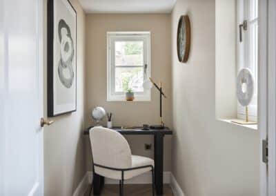 Small room in a staged home brought to life with artwork, ornaments and small study area.